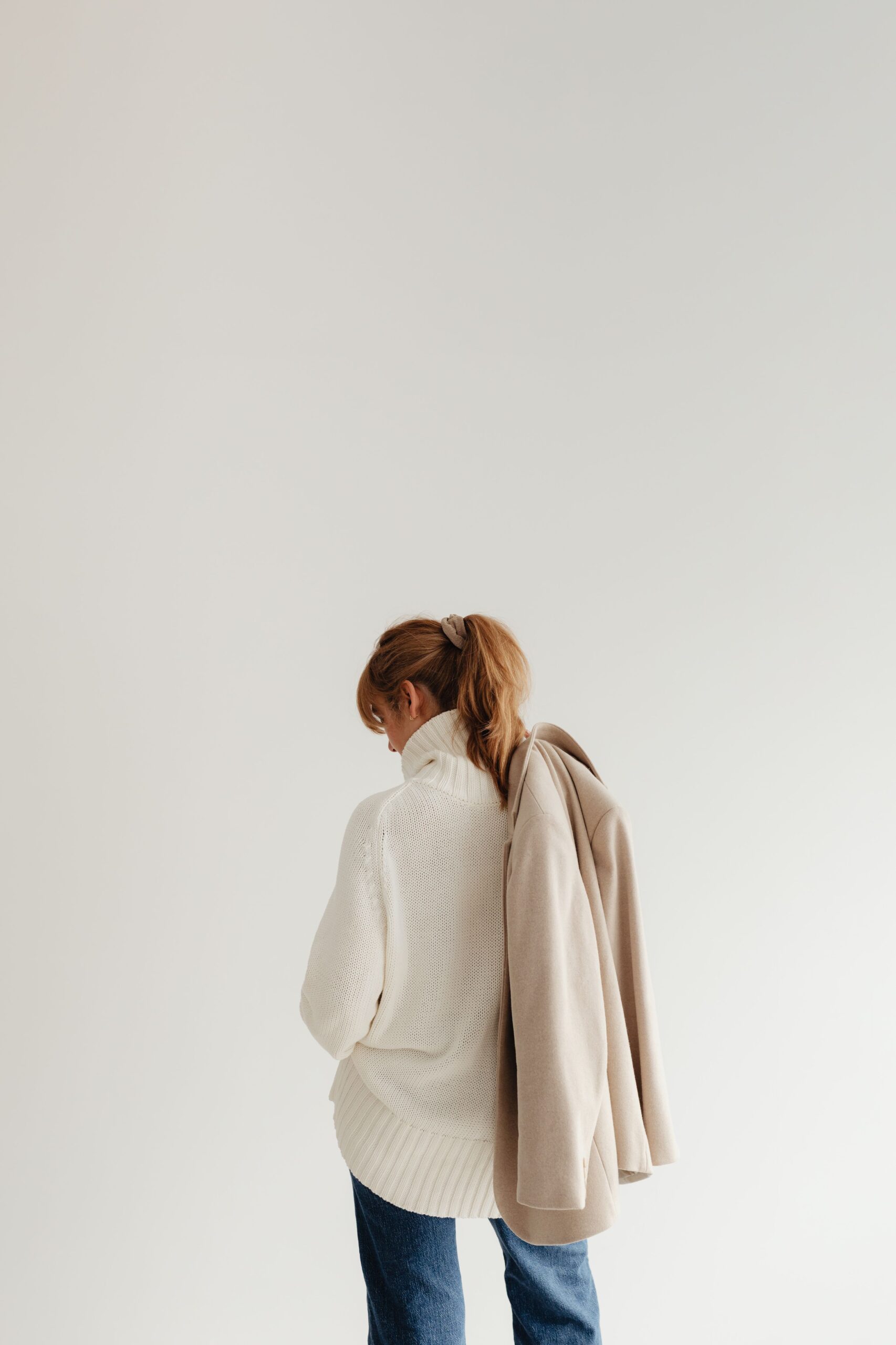 kaboompics_woman-in-white-sweater-beige-wool-jacket-jeans-29417